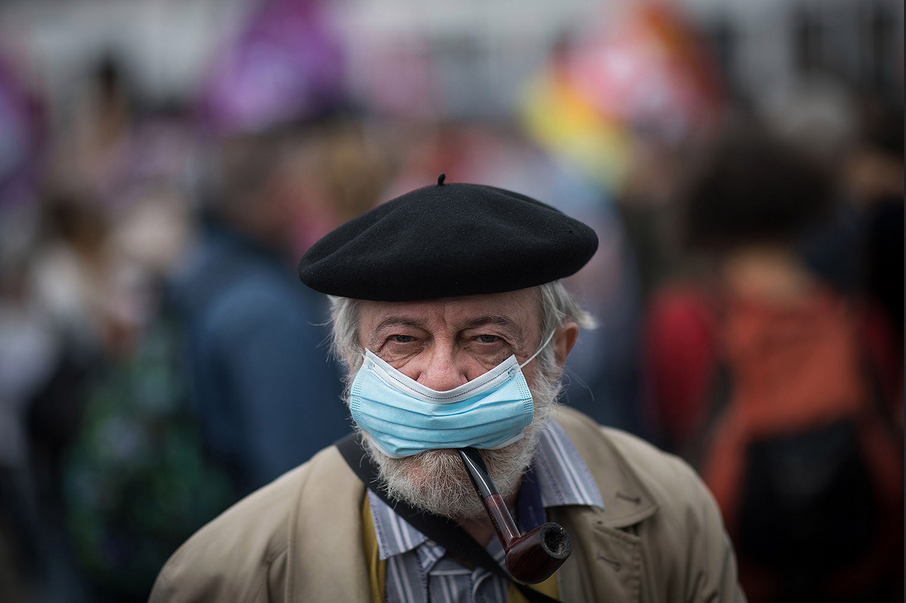 A man smokes a pipe while wearing a face mask during a demonstration in Nantes, France, on June 30 as part of a nationwide day of protests to demand better working conditions for health care workers. LOIC VENANCE/AFP via Getty Images