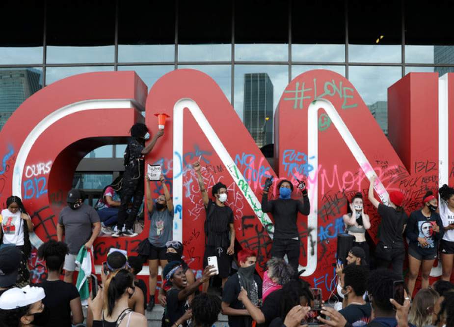 Protesters stand in front of a vandalized logo in front of the CNN Center in Atlanta, Georgia, US.JPG