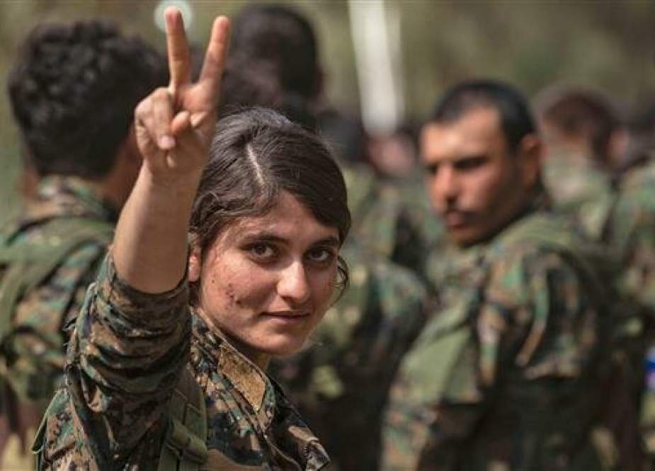 SDF fighter flashes the victory gesture near the Omar oil field in Dayr al-Zawr province in eastern Syria.jpg