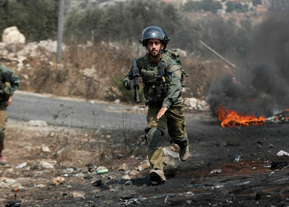 Israeli soldiers run towards demonstrators during a Palestinian protest.jpg