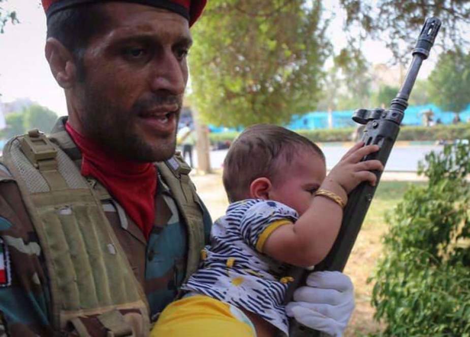Iranian serviceman trying to protect a baby girl in the attack by a Saudi-backed terrorist group in the southwestern Iranian city of Ahvaz.jpg