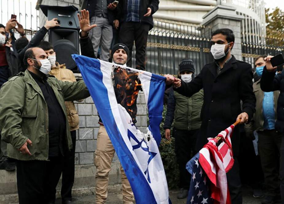 Iranian protesters burn the U.S. and Israeli flags during a demonstration against the the killing of Mohsen Fakhrizadeh in Tehran, Iran.jpg