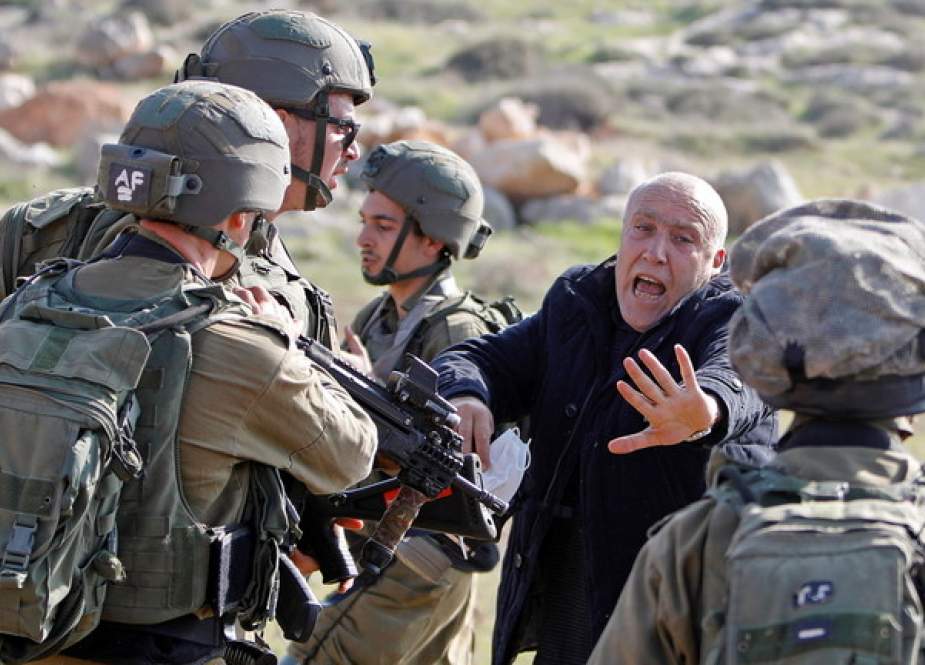Palestinian demonstrator reacts in front of Israeli troops.JPG