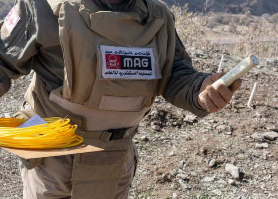 Seorang petugas pembersih ranjau memegang sebuah peledak yang dengannya dia akan meledakkan ranjau darat yang ditanam selama perang Iran-Irak, dekat perbatasan Iran di Irak.