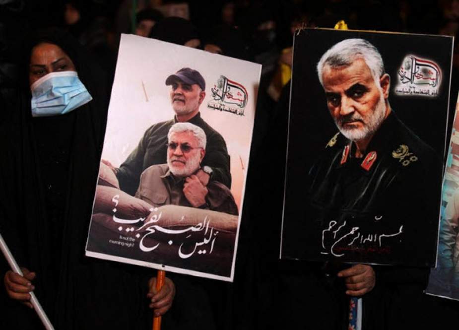Mourners in Baghdad carry photos of Qassem Soleimani and Iraqi militia leader Abu Mahdi al-Muhandis (AFP)