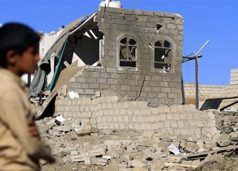 Yemeni child stands amidst debris of a building destroyed in Saudi-led air strikes in Yemen.jpg