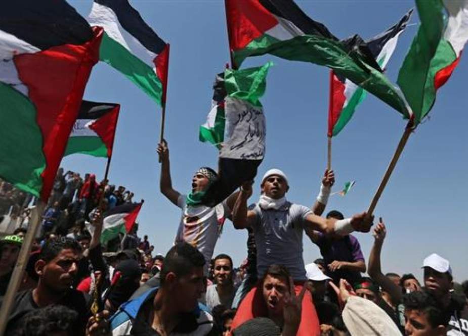 Demonstrators hold Palestinian flags during a protest marking the 71st anniversary of the Nakba Day.jpg