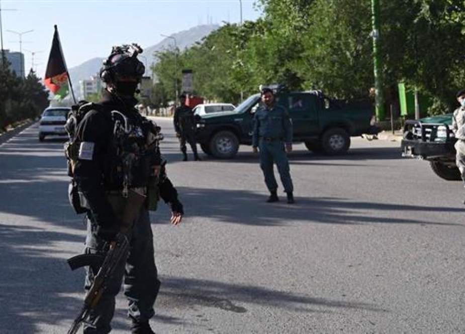 Afghan security personnel stand guard at a checkpoint on a road in Kabul
