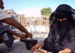 The file photo shows a woman baking bread at her shelter in Khanfar District, Yemen.