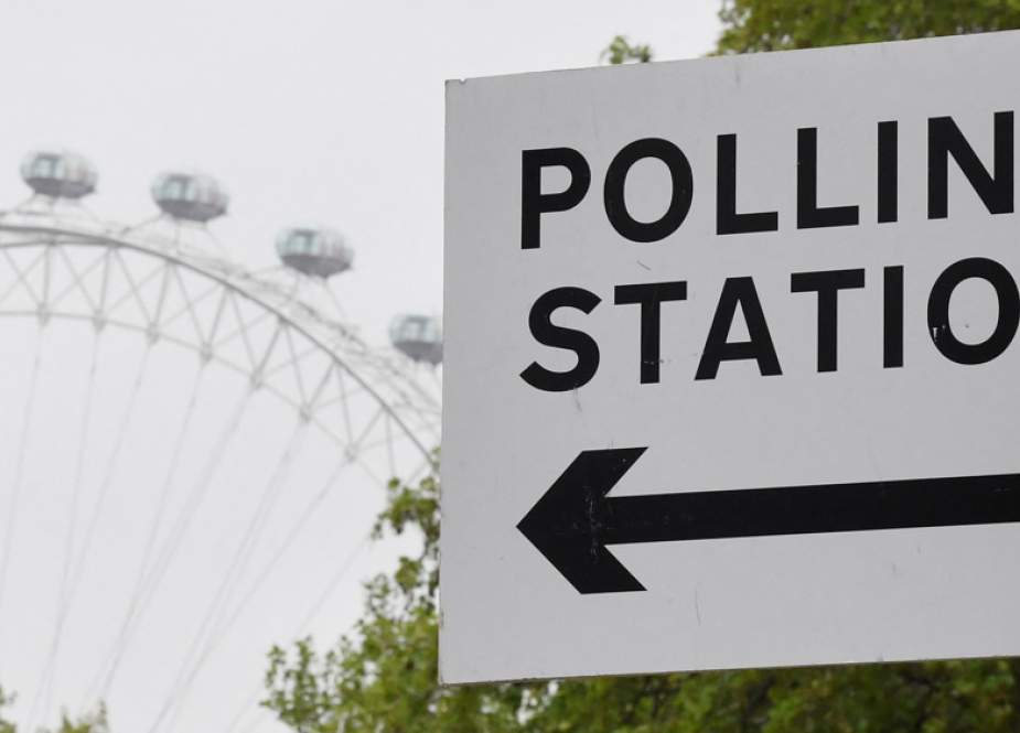 A polling station direction sign is seen with the London Eye wheel behind, ahead of local authority elections, in London, Britain, on May 3, 2022.