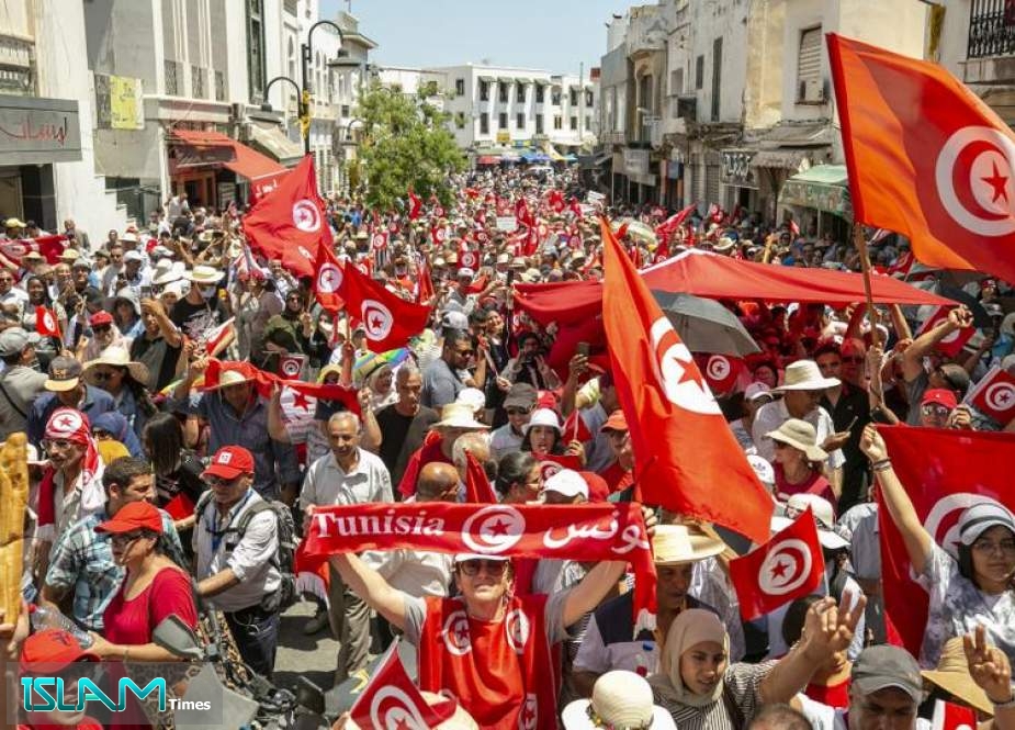 Demonstrators carry flags as they gather during a protest against Tunisian President Kais Saied in Tunis, June 19, 2022.