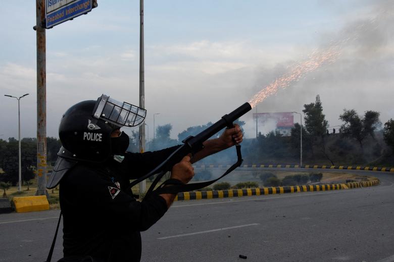 A police officer fires tear gas to disperse people during a protest to condemn the shooting incident on a long march held by Pakistan's former Prime Minister Imran Khan in Wazirabad, in Rawalpindi, Pakistan November 4, 2022.