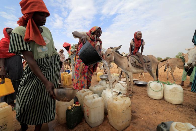 A Sudanese woman who fled the conflict in Sudan's Darfur region and newly arrived, fills her jerrycan with water she fetched from a well that was dug near the border between Sudan and Chad while seeking refuge in Goungour, Chad, May 12.