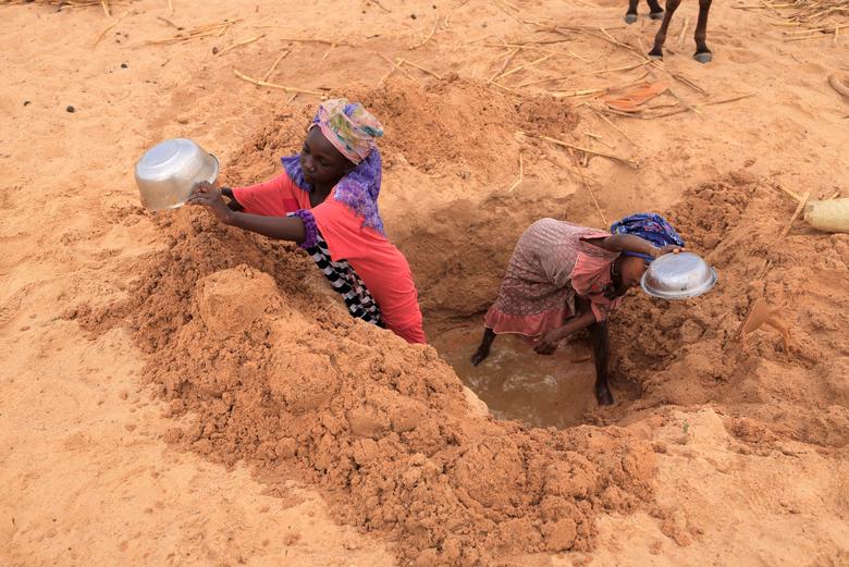 Sudanese girls  who fled the conflict in Sudan's Darfur region and newly arrived, dig a well to fetch water near the border between Sudan and Chad while seeking refuge in Goungour, Chad, May 12.