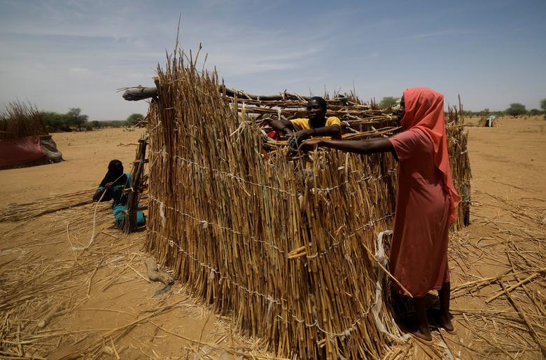 Sudanese refugees, who fled the violence in their country, build their makeshift shelter as they wait  to be placed in a refugee camp near the border between Sudan and Chad in Koufroun, Chad, May 6.