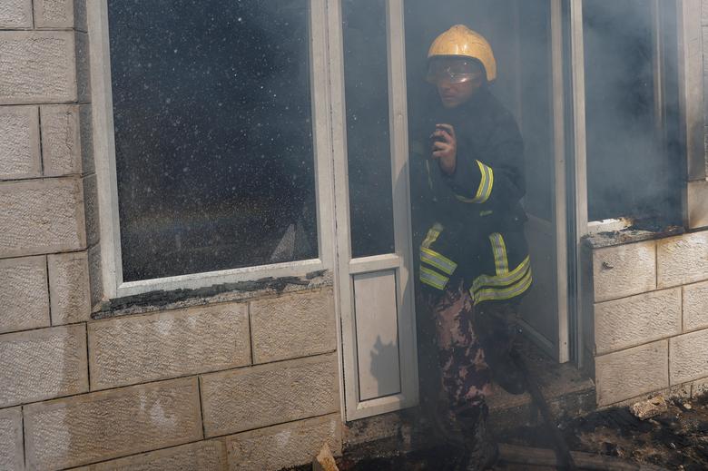 A Palestinian Civil Defence member looks on, as smoke leaves a building, after an attack by Israeli settlers, near Ramallah, in the Israeli-occupied West Bank, June 21, 2023.