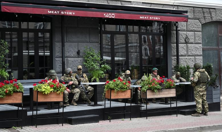 Fighters of Wagner private mercenary group rest in a cafe while being deployed in a street near the headquarters of the Southern Military District in the city of Rostov-on-Don, Russia, June 24.