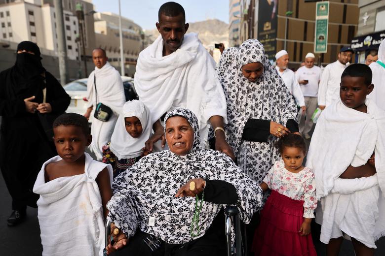 A Sudanese Muslim family walk outside the holy Kaaba, as they arrive from Sudan to perform the annual Haj in the Grand Mosque, in the holy city of Mecca, Saudi Arabia, June 24.