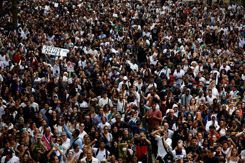 People attend a march in tribute to Nahel, a 17-year-old teenager killed by a French police officer during a traffic stop, in Nanterre, Paris suburb, France, June 29. The slogan reads 
