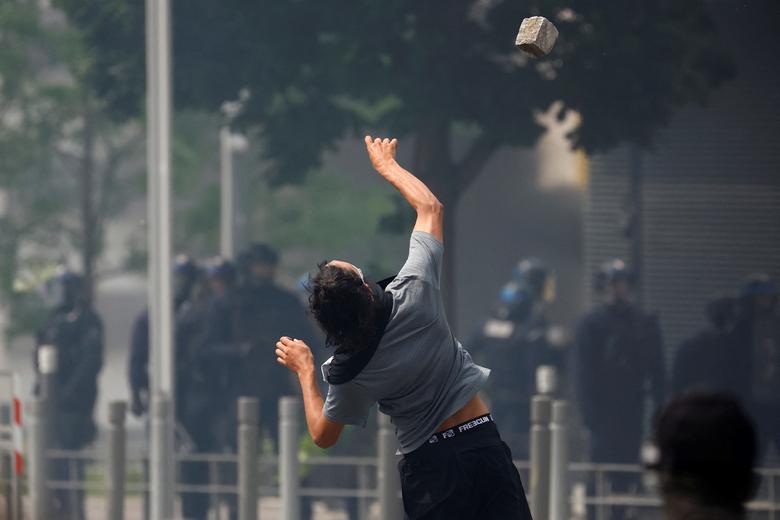 A masked protester throws a stone amid clashes with police during a march in tribute to Nahel, in the Paris suburb of Nanterre, France, June 28.