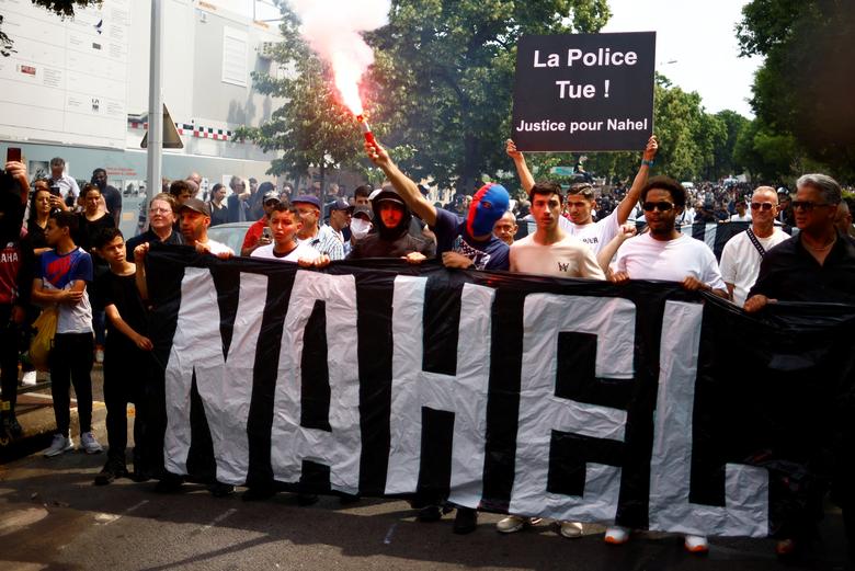 People attend a march in tribute to Nahel, in the Paris suburb of Nanterre, France, June 29. The slogan reads 