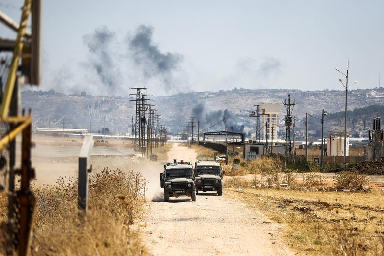 Israeli military jeeps drive on a road leading from a raid on Jenin refugee camp, as seen from Salem checkpoint, the entrance from Israel to Jenin in the Israeli-occupied West Bank July 3.