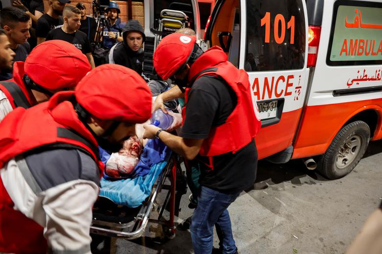 An injured person is transported on a stretcher after a Palestinian was killed during an Israeli military operation, in Jenin, in the Israeli-occupied West Bank July 3.