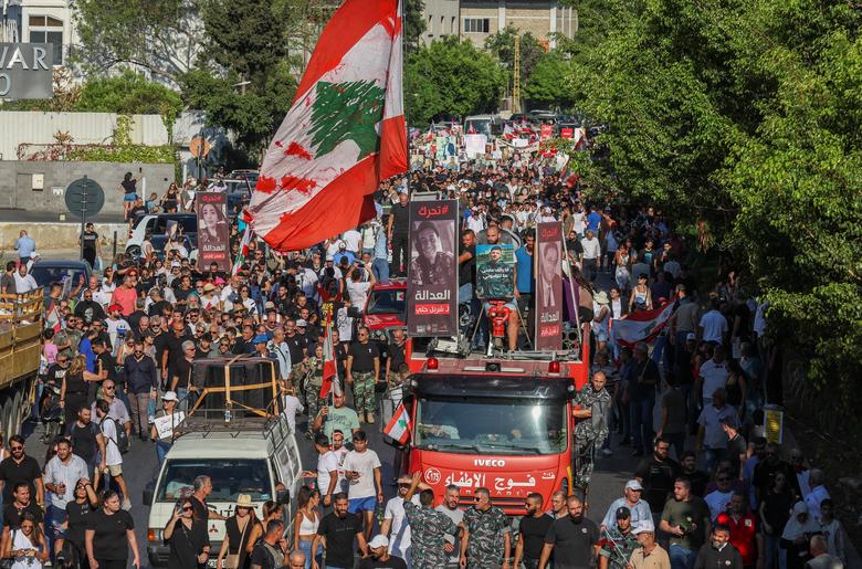 Members of Lebanon's firefighters and families of the victims of the Beirut port blast carry their pictures during a march in Beirut, August 4.