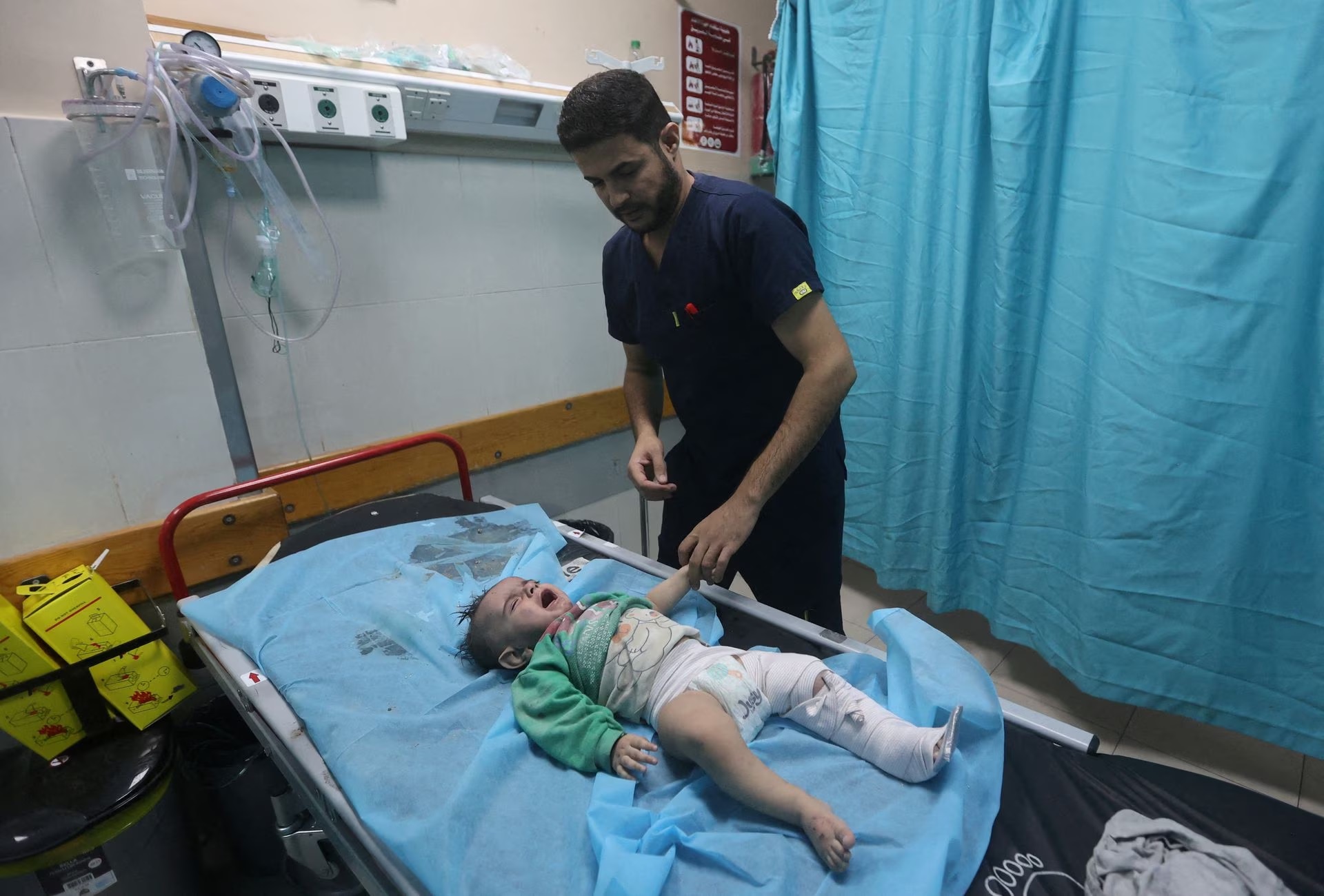 A Palestinian baby, wounded in Israeli strikes, lies on a bed while getting medial attention at a hospital in Khan Younis in the southern Gaza strip.