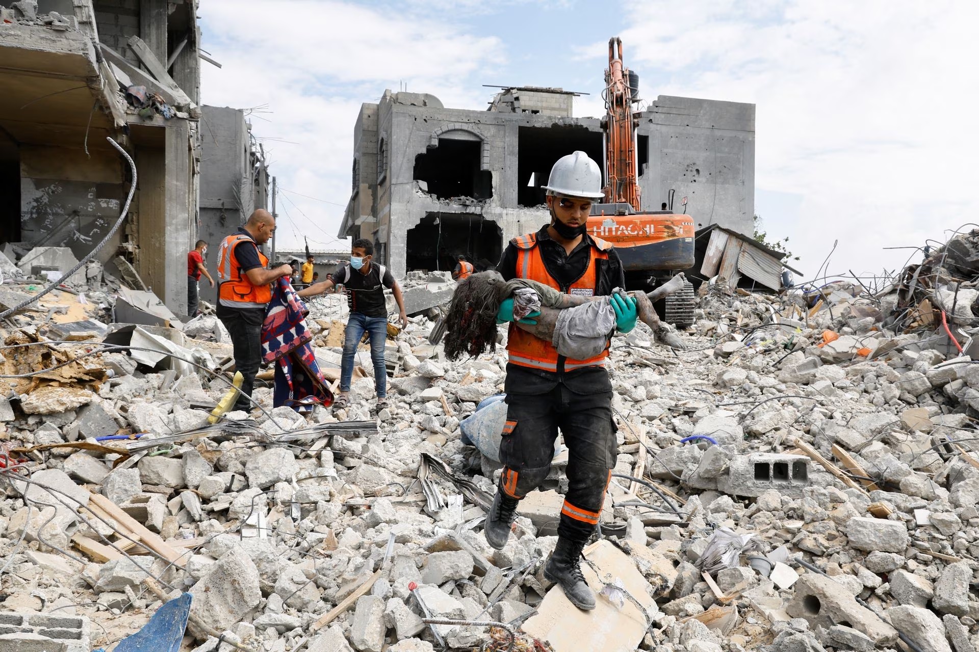 A rescue worker carries a body of a child recovered from under the rubble of a house destroyed by Israeli strikes in Khan Younis in the southern Gaza Strip.