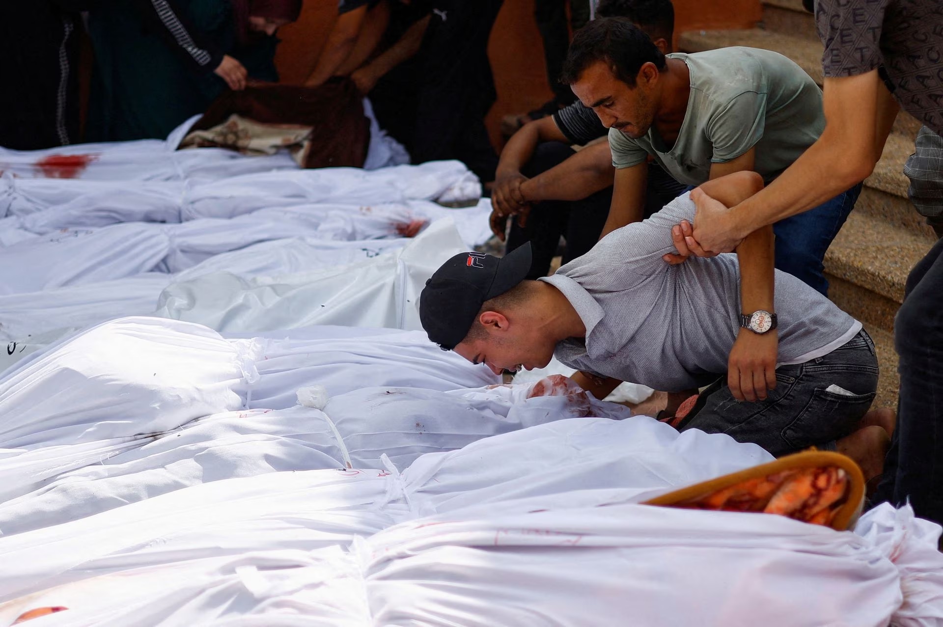 Mourners react next to the bodies of Palestinians killed in Israeli strikes, at a hospital in Khan Younis in the southern Gaza Strip, October 17.
