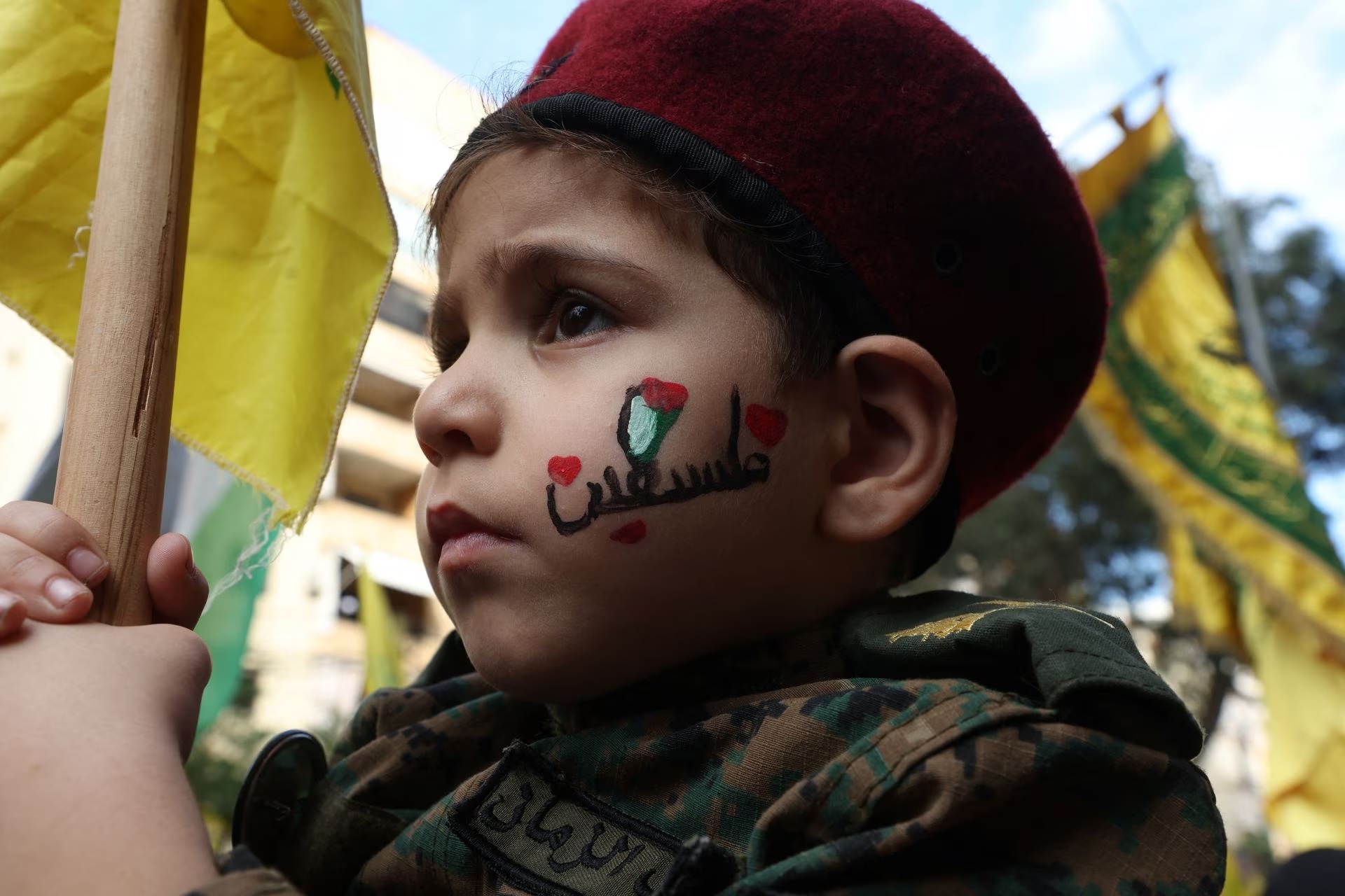 A boy holds a flag as Hezbollah supporters attend a protest, after hundreds of Palestinians were killed in an Israeli blast at Al-Ahli hospital in Gaza.