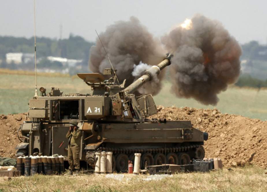 An Israeli 155mm self-propelled howitzer fires artillery shells towards the Gaza Strip