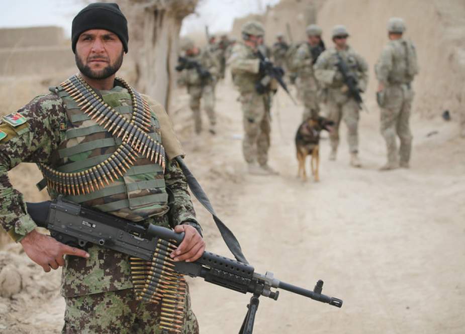 A soldier with the Afghan National Army (ANA) patrols through a village on March 4, 2014 near Kandahar, Afghanistan