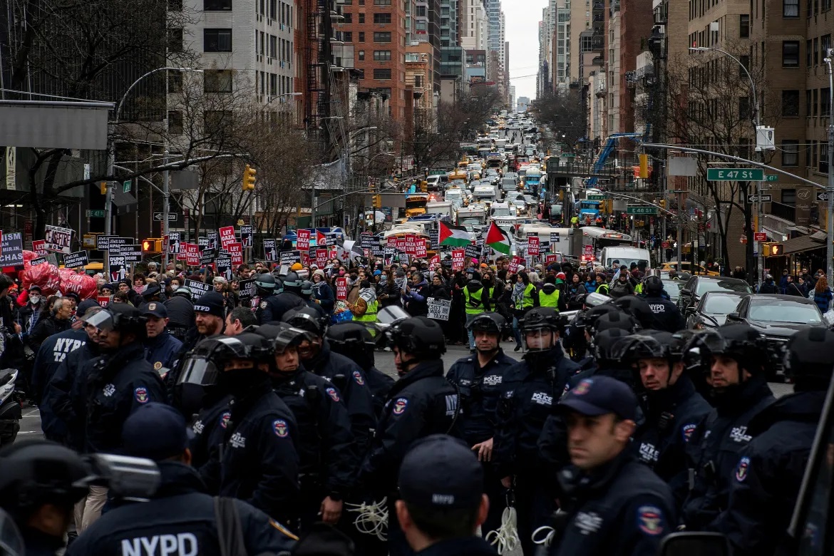 Police officers try to block the march along Second Avenue in New York City.