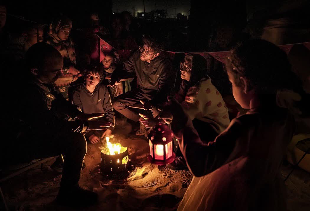 ماہ رمضان کے استقبال کی خاطر فلسطینی بچے اپنے خیموں میں لائٹس روشن کرتے ہوئے