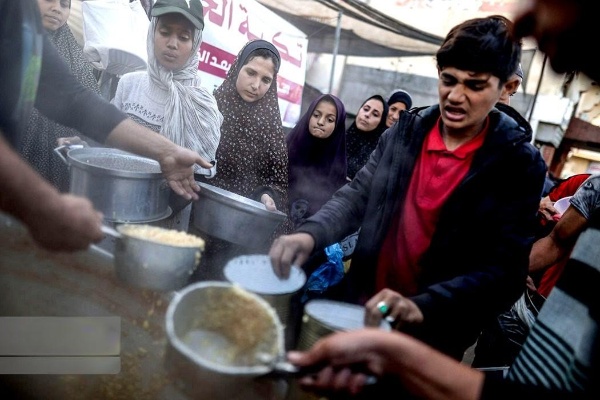 دیر البلح میں فلسطینی مہاجرین افطاری لیتے ہوئے