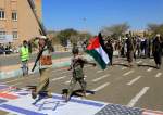 Armed Yemeni men walk over the flags of the US, Israel and Britain in the capital Sana