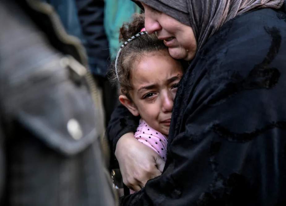 A-Palestinian-woman-holds-a-child-as-they-mourn-their-relatives-killed-in-Israeli-bombardment