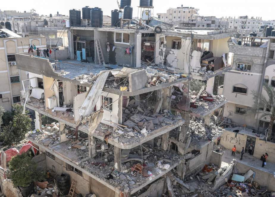 Palestinians inspect damage of a destroyed building in Rafah, Gaza