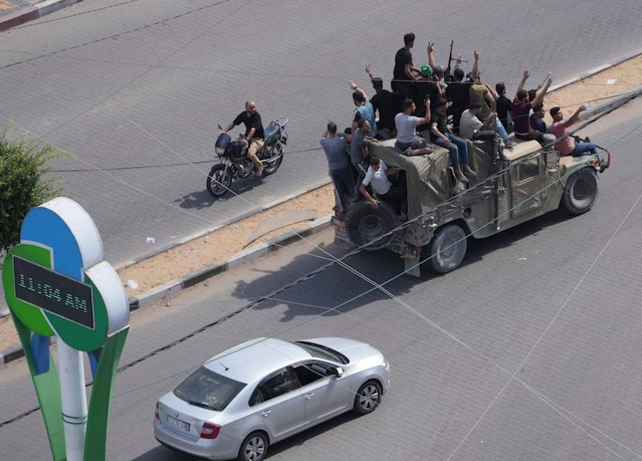 Palestinians drive a captured Israeli military vehicle in Gaza City