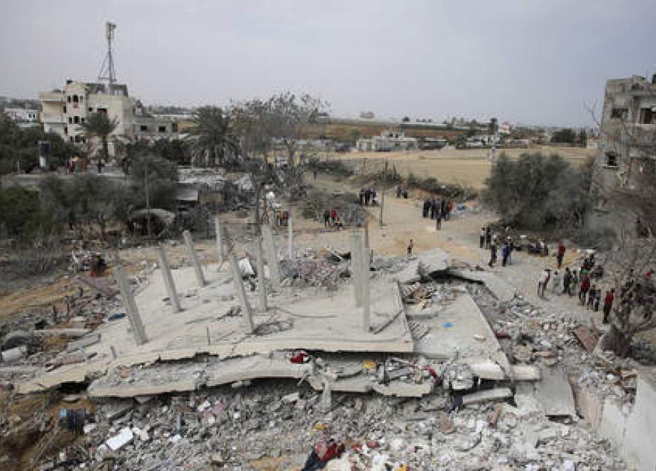Palestinians inspect the ruins of a residential building destroyed in an Israeli airstrike in Rafah, Gaza