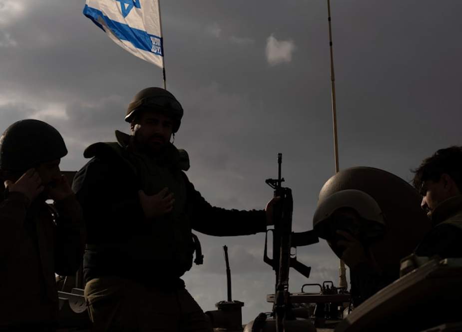 Israeli soldiers work on military vihicle near the Gaza Strip