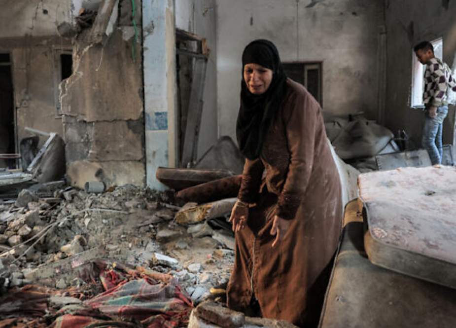 A Palestinian woman cries as she inspects a heavy damaged apartment following Israeli bombardment