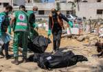 Palestinian paramedics carry away bodies of dead people uncovered in the vicinity of Al-Shifa Hospital in Gaza City