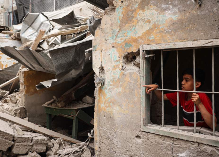 A Palestinian child stands amid the debris of a house destroyed by Israeli bombardment in Rafah Gaza Strip