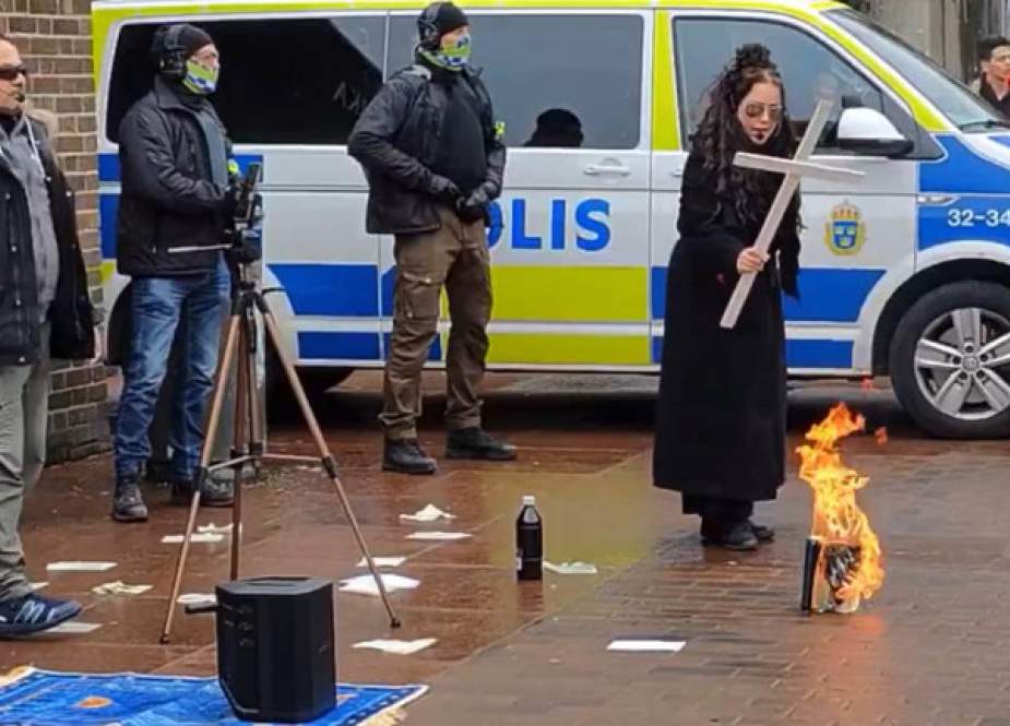 Jade Sandberg is seen torching the Muslim holy book while waving a Christian cross over