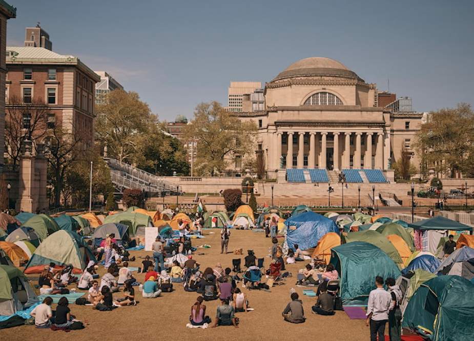 People listen to a speaker at a pro-Palestinian encampment inside the campus of Columbia University