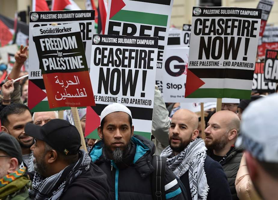 Pro-Palestinian protesters hold placards as they take part in a demonstration in London