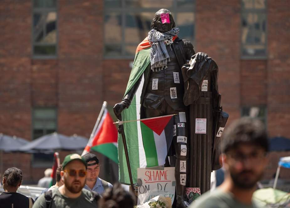 Stickers and Palestinian flag cover a Geoge Wahington statue in George Washington Univ